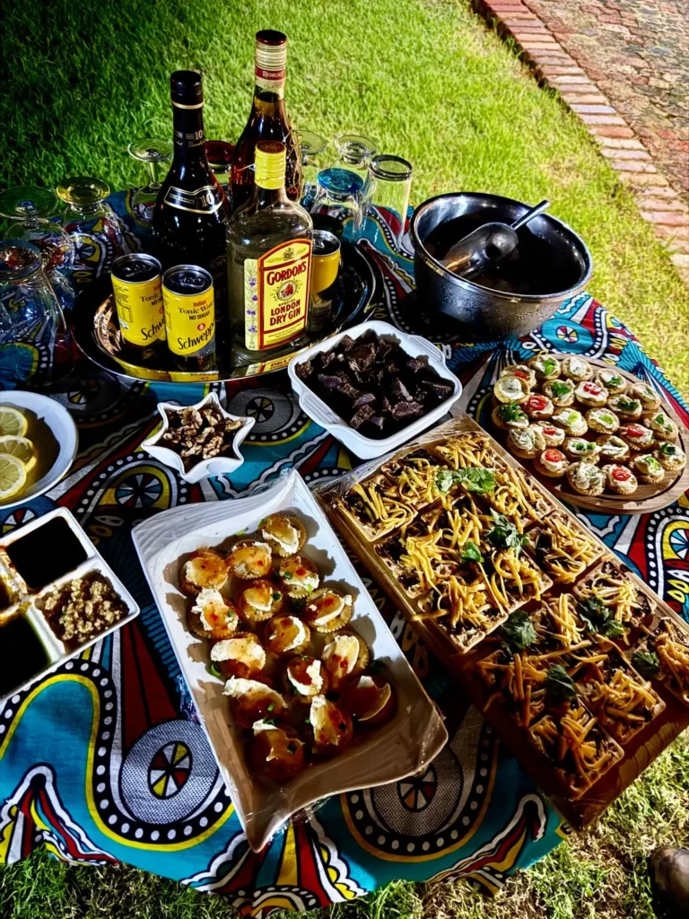 Afrikanisches Buffet mit Snacks, Dips und Getränken auf buntem Tischtuch