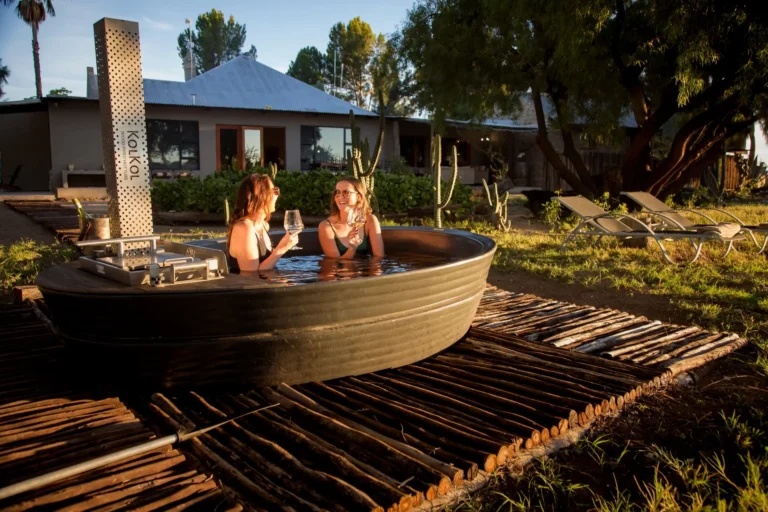 Zwei Gäste im Hot Tub im Garten der Lodge
