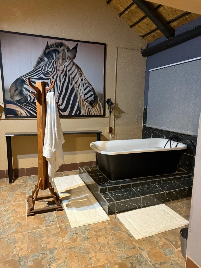 Badezimmer mit freistehender schwarzer Badewanne und Zebra-Bild