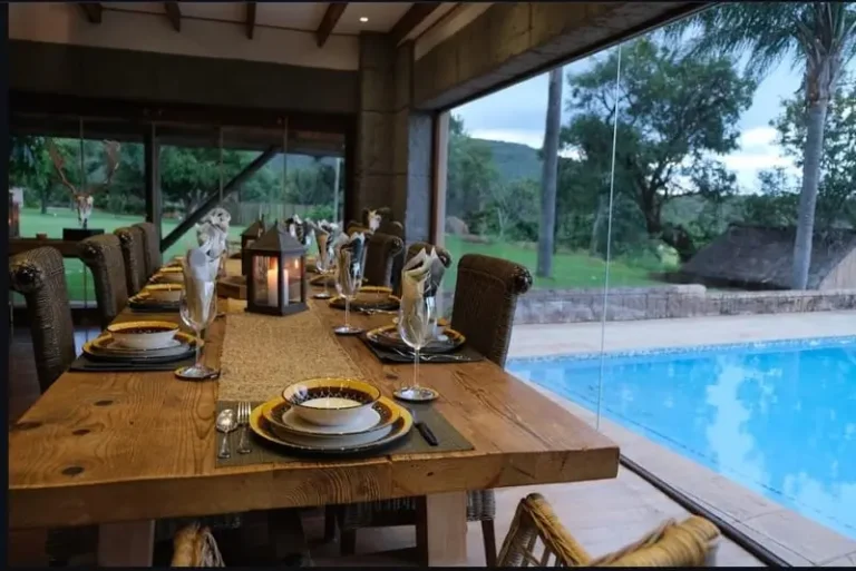 Gedeckter Holztisch mit Weingläsern und Blick auf den Pool
