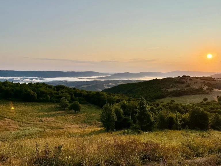 Sonnenuntergang über den bewaldeten Hügeln und Wiesen des Jagdreviers im bulgarischen Balkangebirge