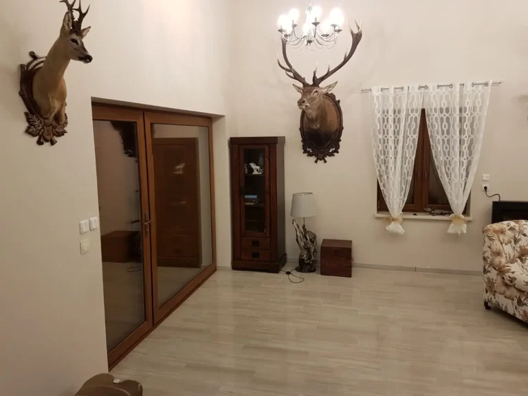 Wohnraum mit Hirschtrophäen in der Jagdunterkunft in Polen