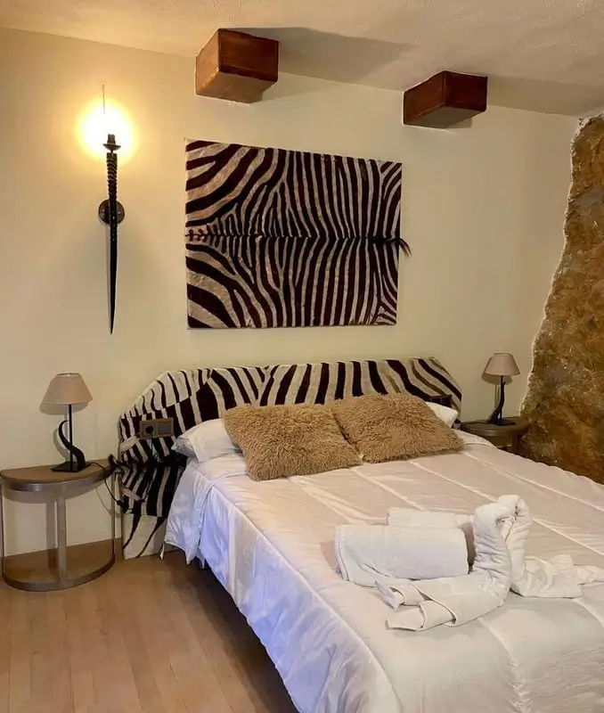 Doppelbett mit Zebrafell an der Wand